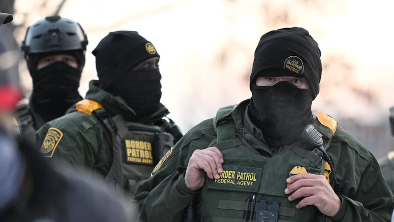 ARCHIVO - Agentes federales observan una manifestación frente al Edificio Federal Bishop Henry...